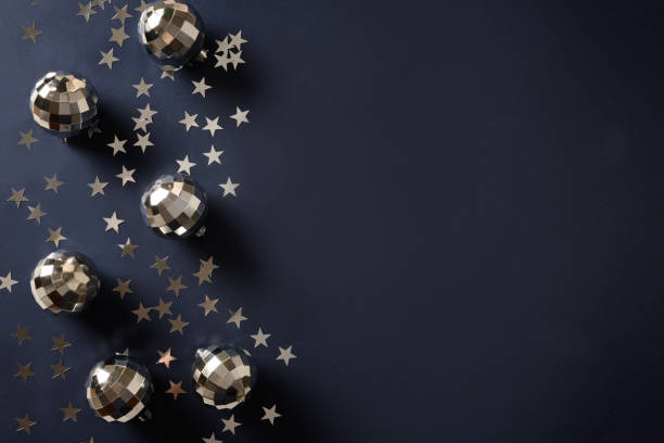 istock Shiny disco balls with rays on navy blue background. Creative party for New Year. 1353429997