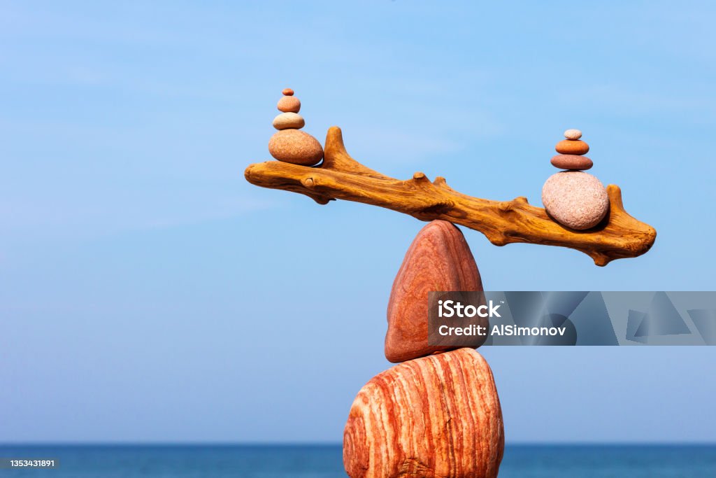 Concept of harmony and balance. The disturbed equilibrium. Imbalance Balanced Rock Zen on the background of the sea. The concept of fall risk and unstable equilibrium Hormone Stock Photo