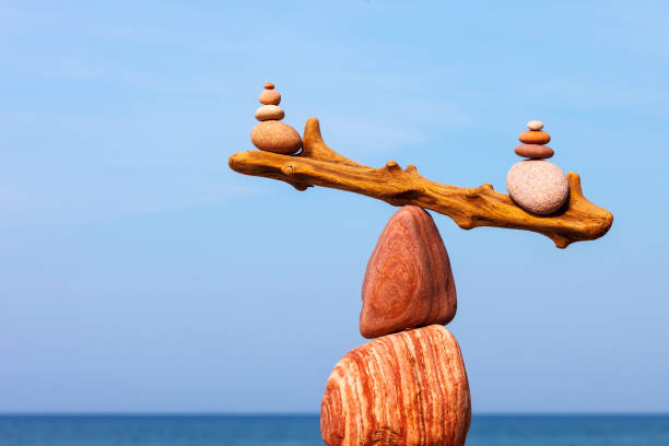 Concept of harmony and balance. The disturbed equilibrium. Imbalance Balanced Rock Zen on the background of the sea. The concept of fall risk and unstable equilibrium hormone photos stock pictures, royalty-free photos & images