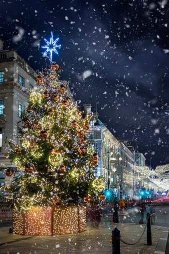 The decorated city center of London for Christmas time with snow falling, England