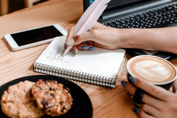 Photo of Student to do list, planning tools, organize plans, projects, checklist, Productivity Works. Create focus while studying, to do list for college. Student girl writing to do list.