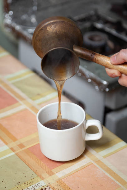 istock Hand pouring coffee from cezve close up 1353434477