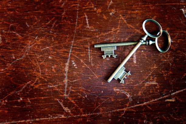 Key with a heart shape on wooden table.