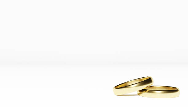 istock Golden wedding rings on white background 1353436367