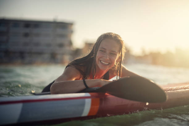 바다에서 sup 패들 보드를 즐기는 십대 소녀 - surfing paddling surfboard sunset 뉴스 사진 이미지