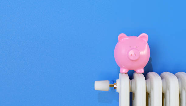 istock Piggy bank on radiator. Saving heating in winter 1353436902