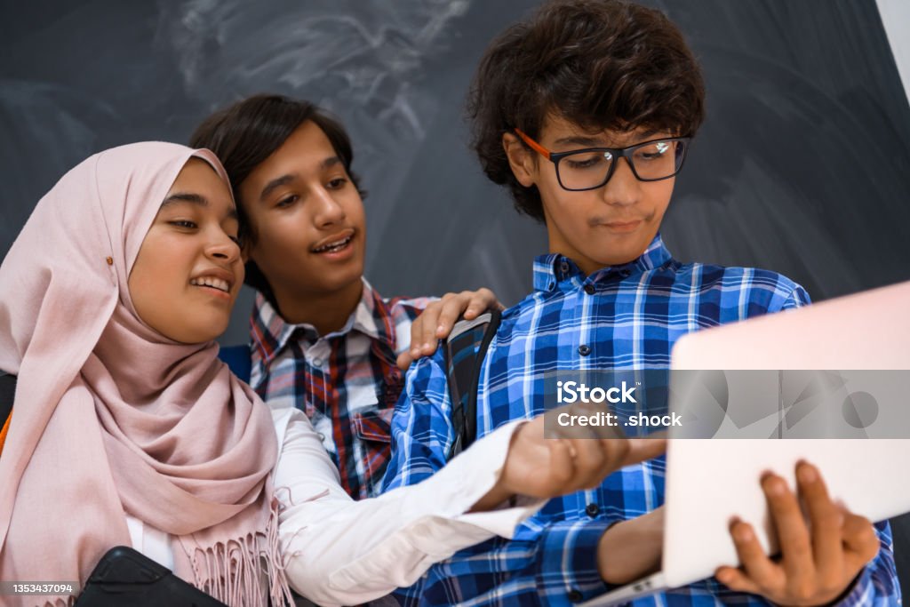 Arabic teenagers team, students group working together on laptop and tablet computer online classroom education concept Arabic teenagers team, students group working together on laptop and tablet computer online classroom education concept. High quality photo Adult Stock Photo