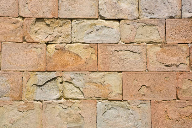 istock Old medieval italian stone wall, built with blocks, recently restored 1353437568