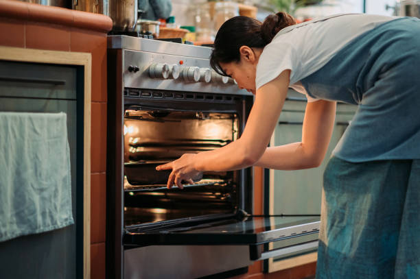 istock Asian chinese baker women putting dough into oven at kitchen 1353438624