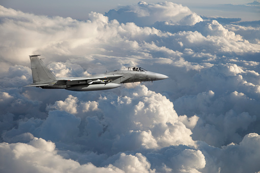 F-15 Fighter Jet flying over clouds