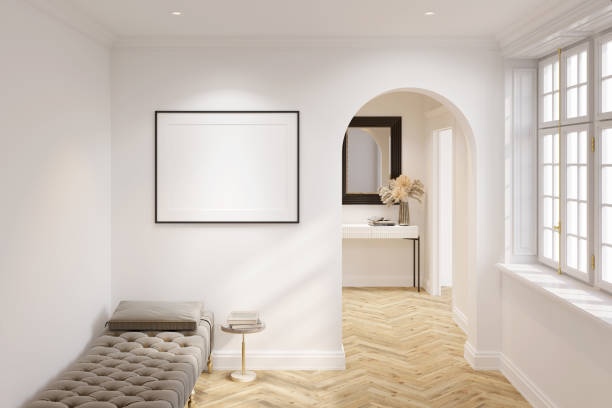 istock White modern-classic interior with blank horizontal poster illuminated by a spotlight, the coffee table next to the couch, arch near the window, mirror above the console in the background. 1353439837