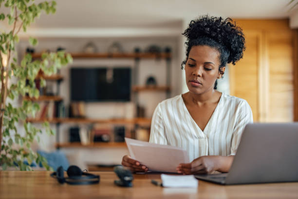 istock Serious african-american woman, reading a document 1353442715