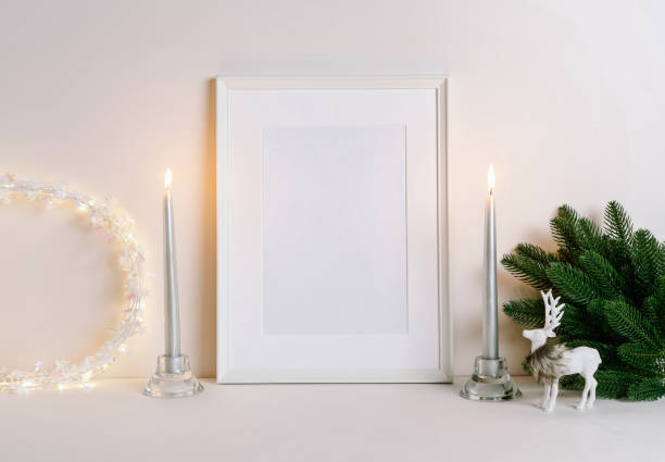 istock Mock up frame with Christmas decorations. Christmas composition with fir tree branch, deer, candle and silver stars on white background. Winter festive concept. 1353442776