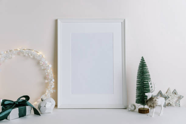 istock Mock up frame with Christmas decorations. Christmas composition with fir tree branch, deer and silver stars on white background. Winter festive concept. Template 1353442860