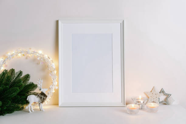 istock Mock up frame with Christmas decorations. Christmas composition with fir tree branch, deer, candle and silver stars on white background. Winter festive concept. 1353442964