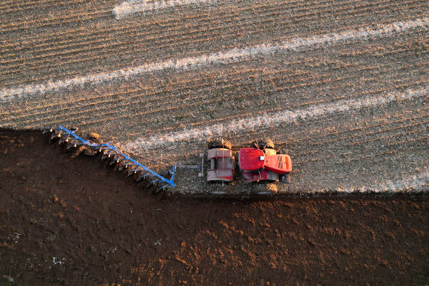 istock Tractor on plowed, aerial view. Ploughing and soil Tillage. 1353444106