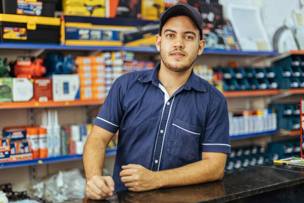 giovane uomo latino che lavora nel negozio di ferramenta - sales clerk store sales occupation retail occupation foto e immagini stock