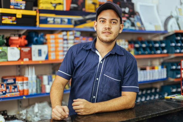 Young latin man working in hardware store Young latin man working in hardware store market vendor photos stock pictures, royalty-free photos & images