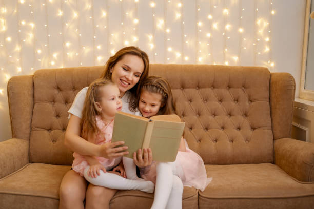 istock Mom reading to her daughters at home 1353446130
