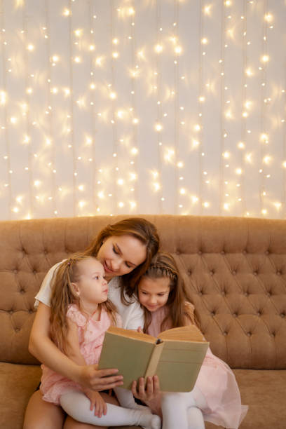istock Mom reading to her daughters at home 1353446135