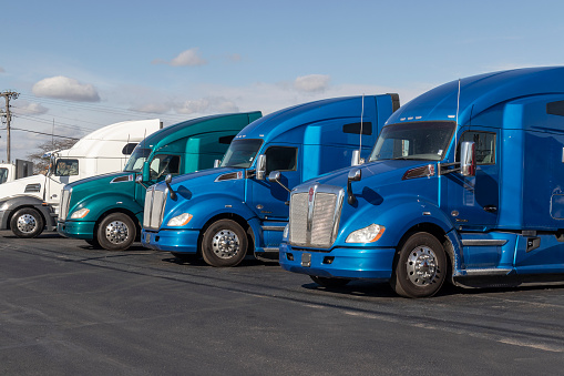 Ft. Wayne - Circa November 2021: Kenworth Semi Tractor Trailer Trucks lined up for sale. Kenworth is owned by Paccar.