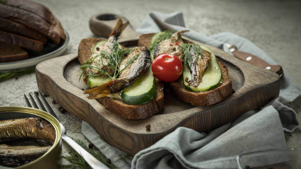 istock Sandwiches with smoked  sprats  on a wooden server 1353447069
