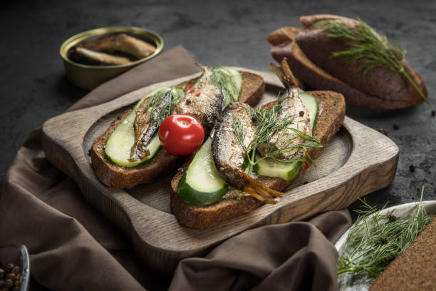 istock Sandwiches with smoked  sprats  on a wooden server 1353447103