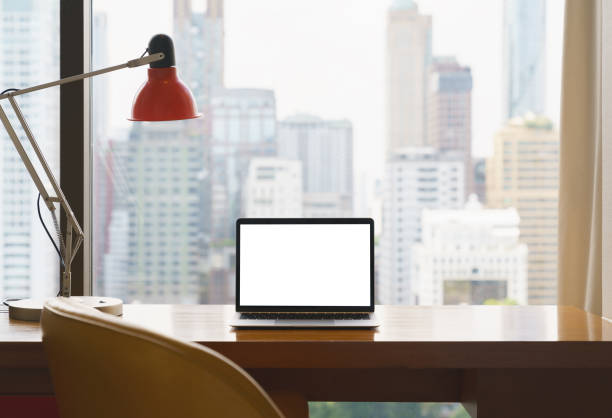 istock laptop white screen display on workspace see through city blur background 1353447255