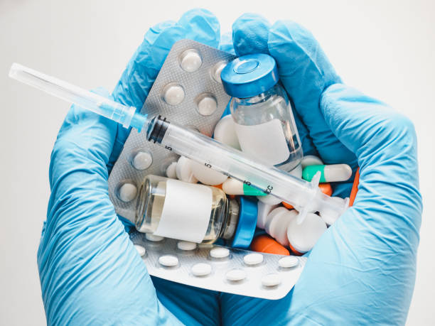 syringe and injection bottle in the hands of a doctor - surgical glove human hand holding capsule imagens e fotografias de stock