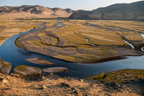 The Orkhon River meanders through a river valley with steppe grass in Mongolia