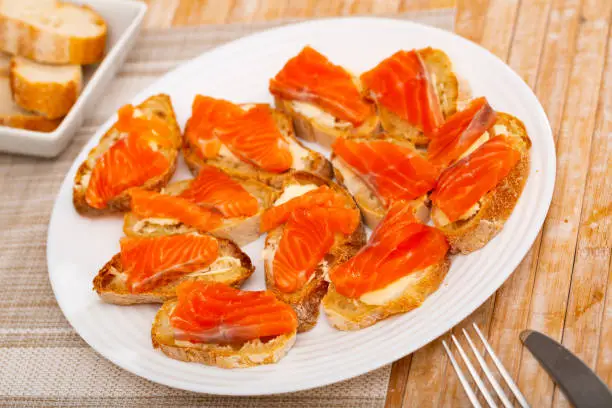 Photo of Sliced baguette with butter and smoked salmon fillet