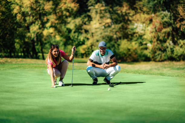istock Golf lifestyle. Young couple having fun on the golf course 1353448927