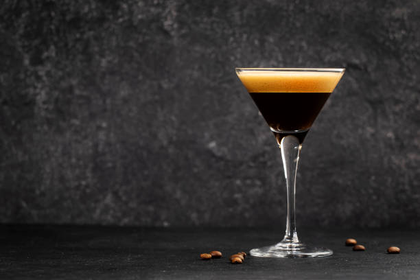 istock Espresso martini cocktail with vodka, coffee liqueur, syrup and ice, black background, bar tools 1353449826