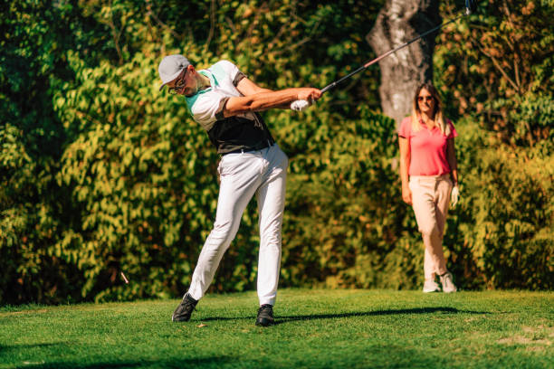 istock Golf swing. Couple on the golf course 1353450984