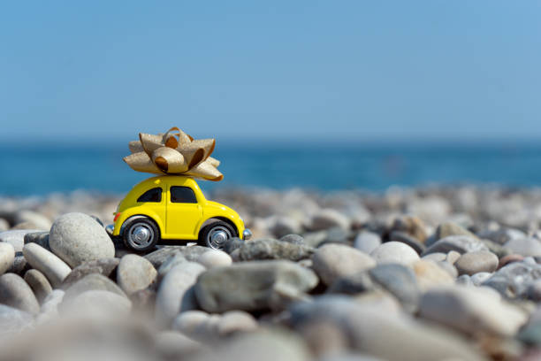 istock A yellow car with a bow on its top standing on the seaside 1353456551