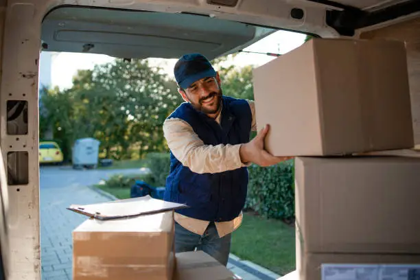 Deliveryman arranging packages in his van before delivering.