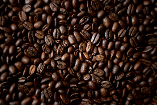 Granos de café tostados frescos en una pila sobre un fondo rústico photo