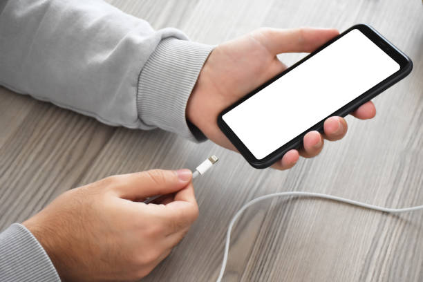 istock Hands plugging in and charging smart phone (Clipping Path) 1353458692