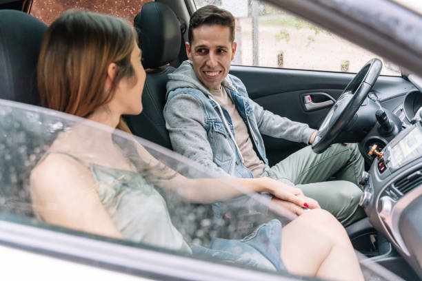 istock Side view of cheerful couple smiling inside a car seat. 1353459441