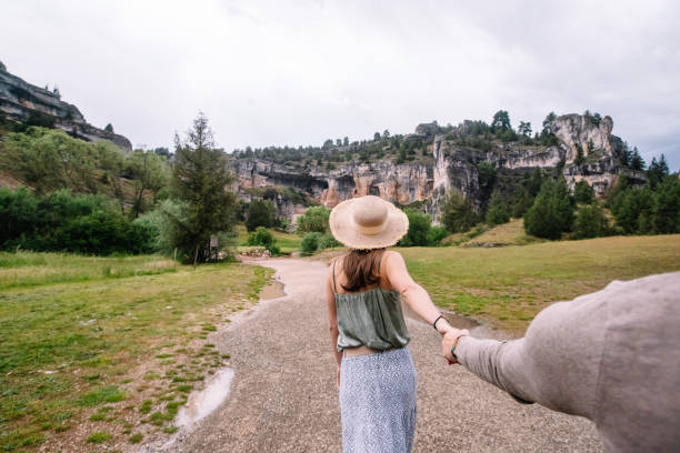 Side view of unrecognizable woman pulling her boyfriends hand taking a walk in nature. Horizontal view of woman traveling in the Lobos river canyon in Soria. People and travel destinations in Spain. point lobos state reserve stock pictures, royalty-free photos & images