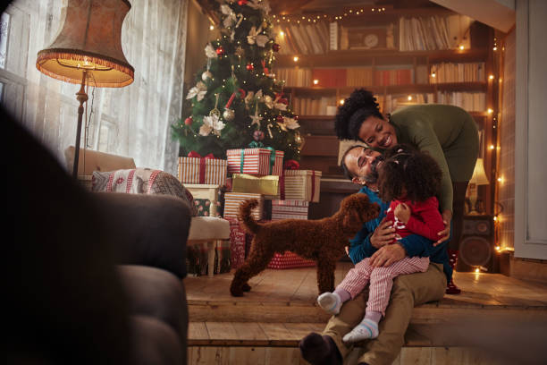 Mixed race family hugging while spending Christmas at home stock photo