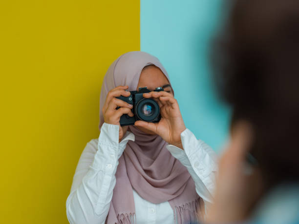 a photo of a young arab teenager having fun with a camera. Selective focus a photo of a young Arab teenager having fun with a camera. Selective focus. High quality photo muslim photographer stock pictures, royalty-free photos & images