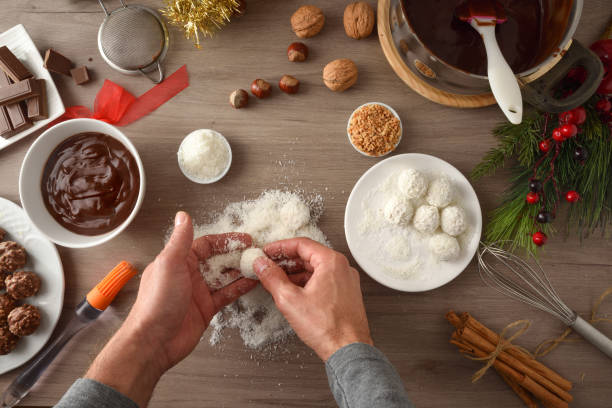 istock Man making coconut sweets on kitchen bench for christmas top 1353462621