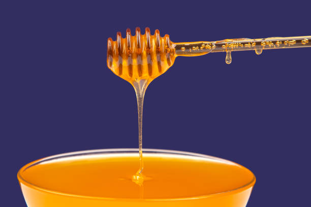 istock fresh fragrant honey dripping from a spoon into a plate on a blue background. organic vitamin nutrition 1353465392