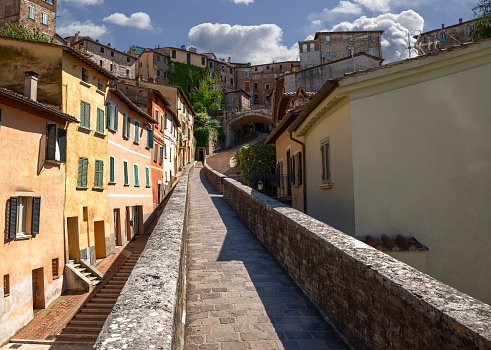 Perugia, Umbria, Italy. August 2021. Amazing view in the historic center: the ancient aqueduct is a magnificent promenade overlooked by the colorful houses. Beautiful summer day.