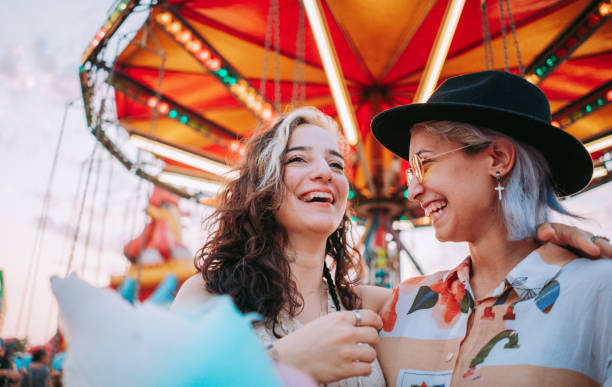 istock Happy girlfriends are make fun together in fun fair 1353467411