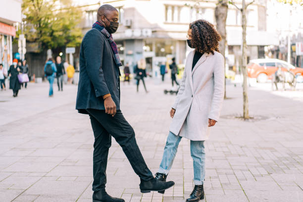 istock Foot bump greeting on the street. 1353472339