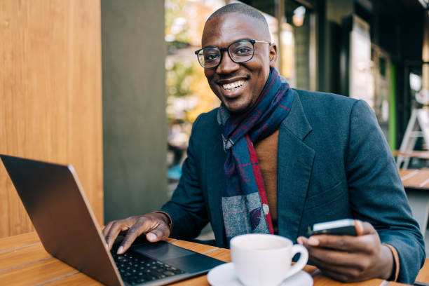 istock Young man sitting in coffee shop and using laptop. 1353472475