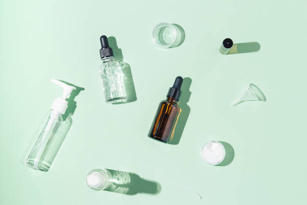 istock Mock-up of empty bottles for cosmetics made of dark and transparent glass on light green background. Body and face treatment and spa. natural beauty products. massage oil. Copy space. Flat lay. 1353473199