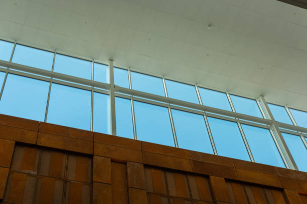 istock Large glass windows letting in light in a tall room.. 1353474319